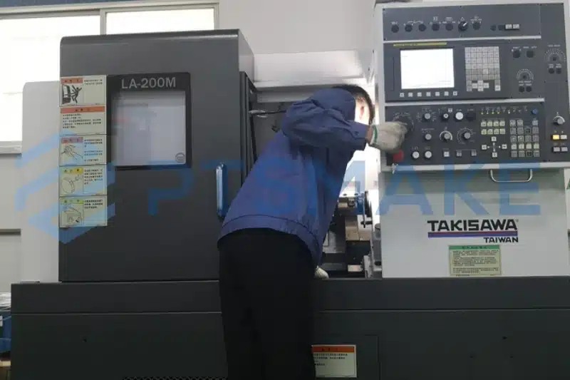 Technician inspecting TAKISAWA CNC lathe