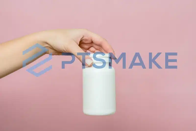 Hand holding white supplement bottle