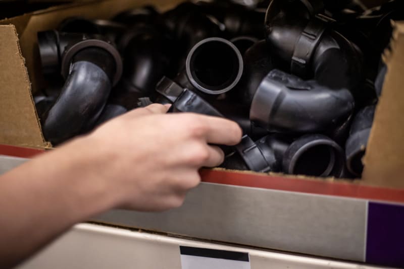 Box of black plastic elbow pipe fittings