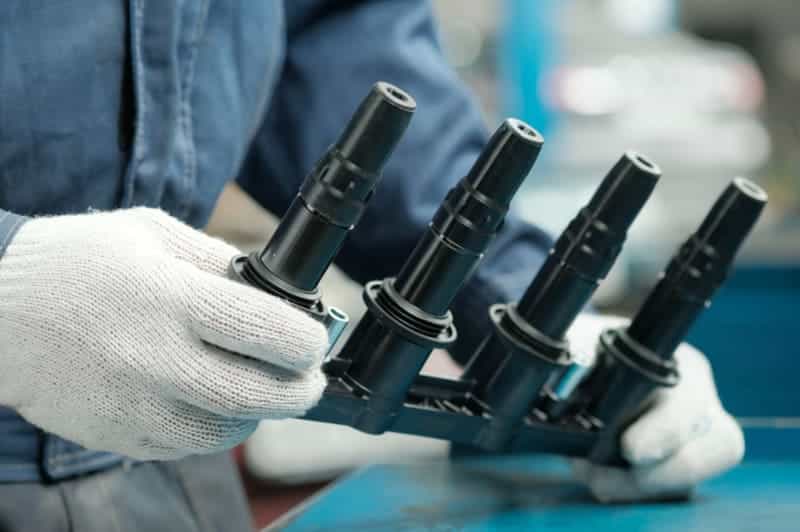 Worker handling black plastic automotive components