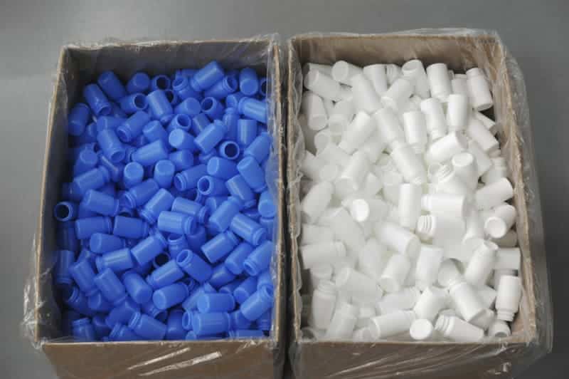 Blue and white plastic caps in boxes