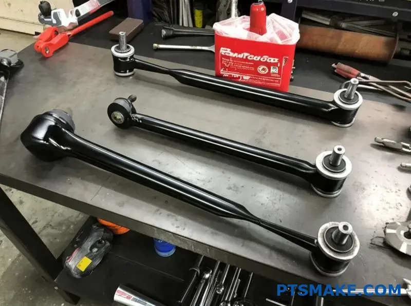 reinforced black custom control arms on garage table